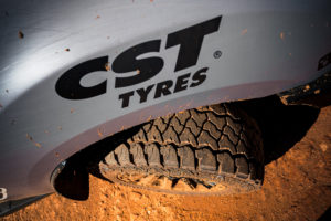 View pf CST Tyres logo on vehicle fender and showing front left side tyre turning outward.