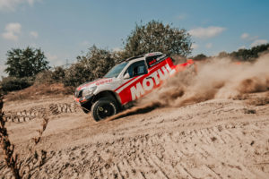CST Sponsored team BAS AUTO SPORT vehicle in an action shot, kicking up dirt.