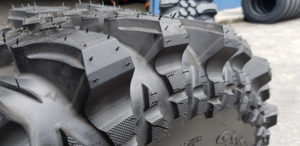 Closeup side angle view of custom grooved tread blocks on a CST Land Dragon