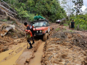 Team 4x4 Malaysia Land Rover off-road vehicle with Land Dragon tires on rough and muddy terrain.