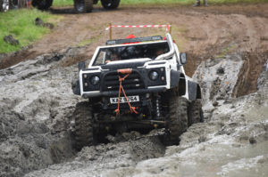 Image of white Land Rover with CST Land Dragon tires in the in the UK, action photoshoot, climbing up very muddy hill.