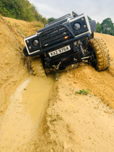 Image of white Land Rover with CST Land Dragon tires in the in the UK, action photoshoot on muddy off-road terrain.