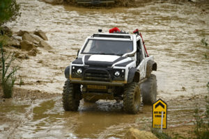 Image of white Land Rover with CST Land Dragon tires in the in the UK, action photoshoot racing through on muddy off-road terrain.