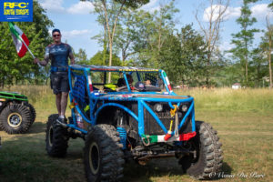 Driver Simone Cognini at the wheel and Dario Lacchio standing on their 4X4 vehicle.