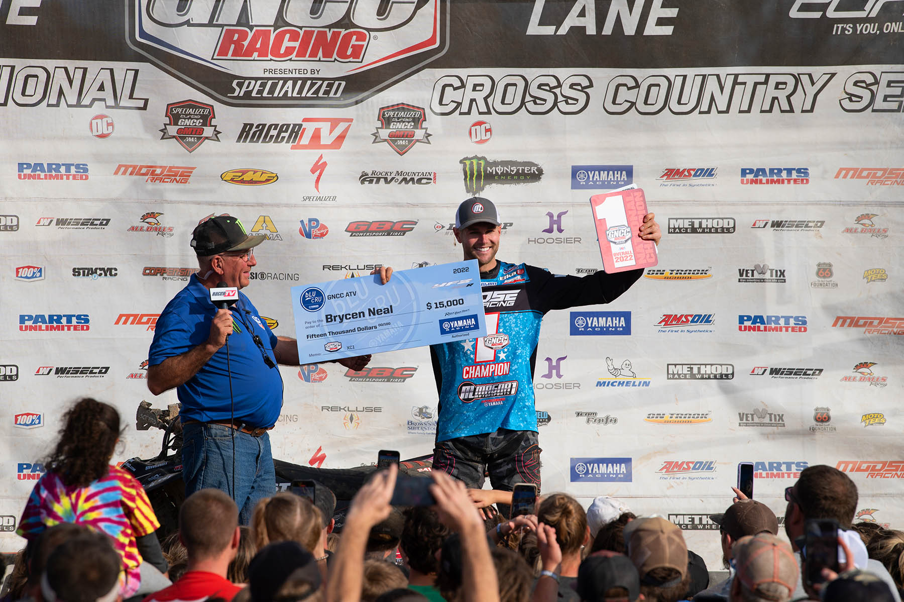 ATV Racer Brycen Neal holding up his check and trophy